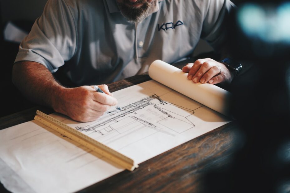 An architect working on a draft with a pencil and ruler