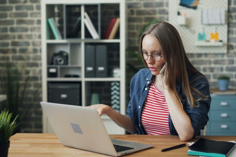 a woman sitting at a table using a laptop computer