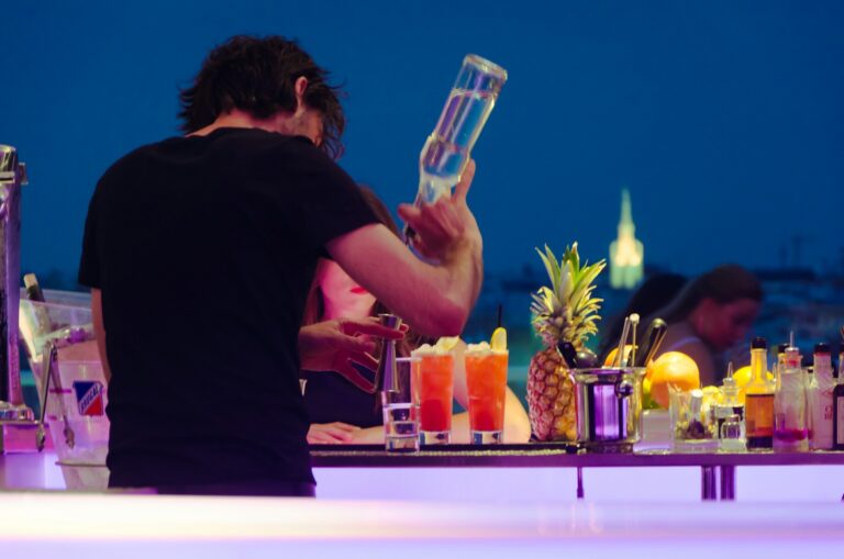 man in black t-shirt preparing tequila at the counter